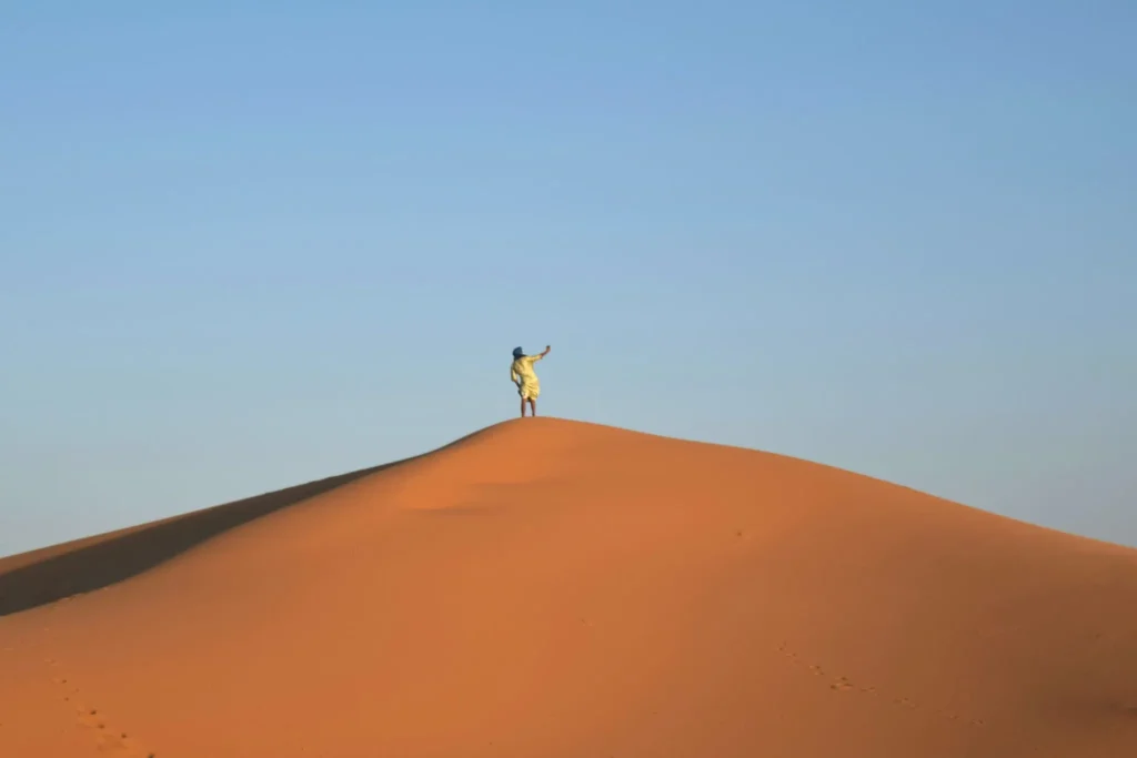 man taking a selfie from a sand dune during a sahara desert tour morocco
